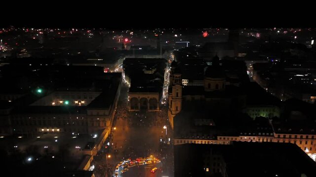 Aerial shot at midnight of fireworks and firecrackers lighting up downtown Munich, Germany, Odeonplatz. Feldherrnhalle and Theatinerkirche stand as part of festive scene. Silvester Feuerwerk Muenchen