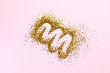 Beautiful golden confetti on a pink background