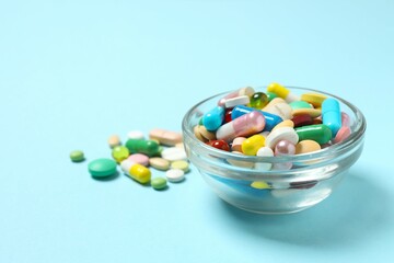 Various pills in a bowl on color background