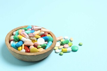 Various pills in a bowl on color background