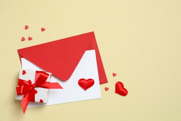 Paper card with envelope, gift box and hearts on color background