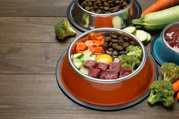 Dry pet food and natural products on wooden table, closeup. Space for text