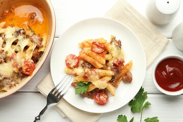 Flat lay composition with delicious pasta casserole served on white wooden table