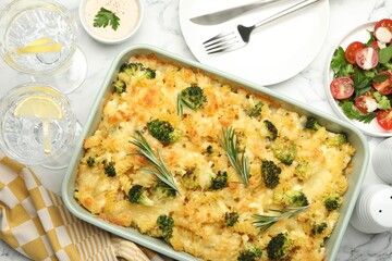Tasty pasta casserole with cheese and broccoli served on white marble table, flat lay