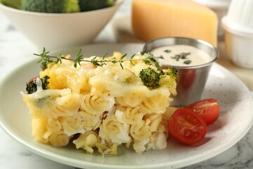 Tasty pasta casserole with cheese and broccoli served on white marble table, closeup
