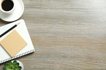 Workplace with notebook, pencil, green plant, cup of coffee, top view 