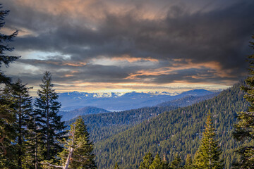 A gorgeous winter landscape with snow capped mountains surrounded by lush green trees at Lake Tahoe in Crystal Bay Nevada USA.