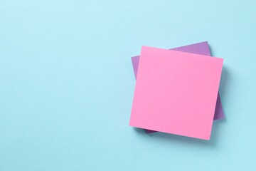 Top view of stack of colorful sticky notes on blue background