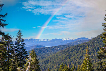 A gorgeous winter landscape with snow capped mountains surrounded by lush green trees at Lake Tahoe...