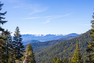 A gorgeous winter landscape with snow capped mountains surrounded by lush green trees at Lake Tahoe in Crystal Bay Nevada USA.