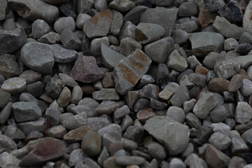 A closeup view of gravel showcasing a variety of stone sizes and shades that can be used for construction, landscaping, or other purposes