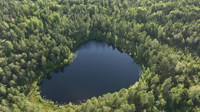 Drone footage of the Nackern Lake surrounded by dense vegetation in Bestorp, Linkoping, Sweden