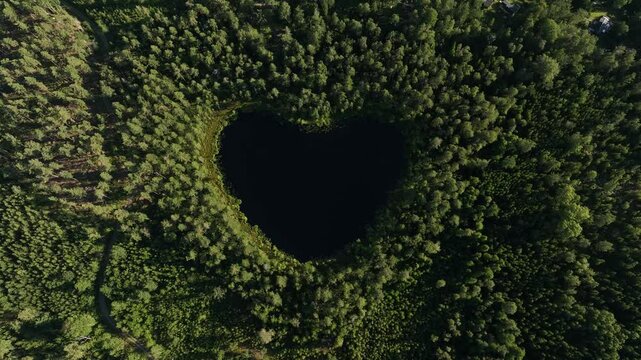 Aerial footage of the heart-shaped Nackern Lake surrounded by dense vegetation in Bestorp, Sweden