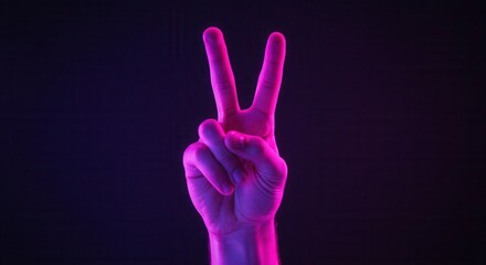 Obraz premium Neon pink hand gesture in victory symbol with dark background