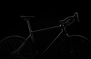 Silhouette of black bicycle on black background.