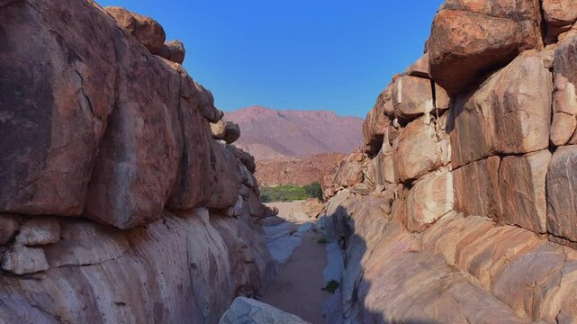 Stunning aerial footage showcasing the dramatic rocky landscapes of Namibia. The scene highlights arid terrain, scattered boulders, and unique geological formations under a clear blue sky.