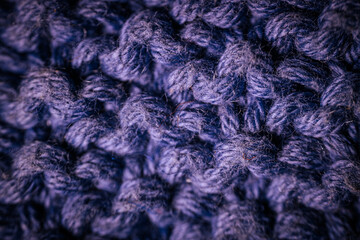 A macro view of dark blue knitted fabric showcasing the rich texture and thick yarn weave. The soft...