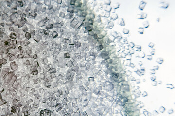 Macrophotography of white sugar crystals, substance crystals under the microscope, unhealthy sugar, sugar compounds, sweetening products.