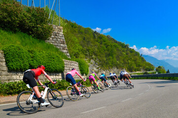 Professional cycling race. Cycling peloton ride on the road in Italy under blue sky. Stage of mountain Spring cycling race in Italy