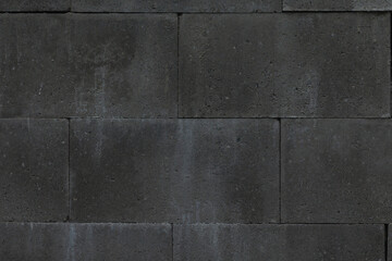 A closeup view of a weathered and dark shingle wall, beautifully showcasing the intricate texture of building material set in an outdoor environment