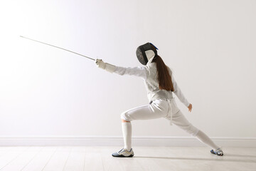 Fencer with epee practicing indoors. Combat sport