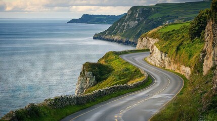 Obraz premium A winding road along a cliffside beside a body of water and a cliff in the backdrop