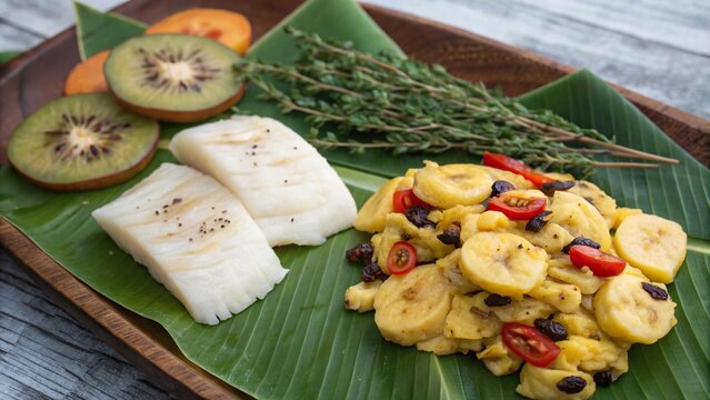 Enjoying traditional ackee and saltfish served on a vibrant banana leaf in a warm Caribbean setting