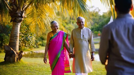 Retired senior indian couple walking hand in hand, sharing tender moments amid lush park greenery during warm golden hour sunlight - Powered by Adobe