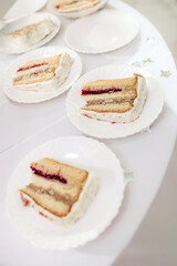 Cream wedding cake on plates, traditional cakes at the wedding, cutting the cake.