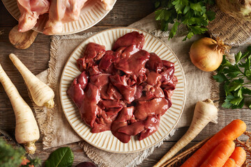 Raw chicken liver and meat with fresh vegetables - Ingredients for homemade broth or soup