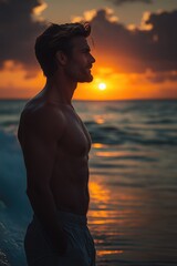 Fototapeta premium A person stands in the ocean as the sun sets in the background