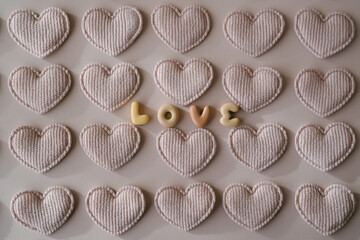 An arrangement of beige fabric hearts surrounding the word 