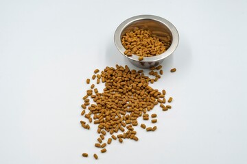 Dry food for domestic cats and dogs in a bowl on a white background