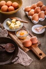 Ingredients for scrambled eggs or omelet, organic brown eggs with butter and salt with iron pan
