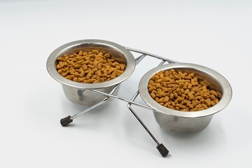 Dry food for domestic cats and dogs in a bowl on a white background