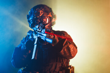 Tactical soldier aiming weapon in colorful light environment showcasing action concept
