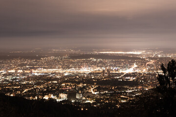 Fototapeta premium Illuminated Cityscape at Night with Cloudy Sky in Zurich, Switzerland
