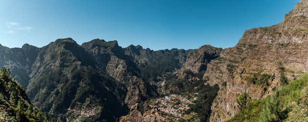 Panorama traditionelles Bergdorf auf Madeira – Panoramaaufnahme mit terrassierten Feldern und roten Ziegeldächern inmitten üppiger Natur bei strahlend blauen Himmel
