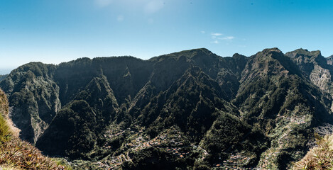 Panorama traditionelles Bergdorf auf Madeira – Panoramaaufnahme mit terrassierten Feldern und roten Ziegeldächern inmitten üppiger Natur bei strahlend blauen Himmel
