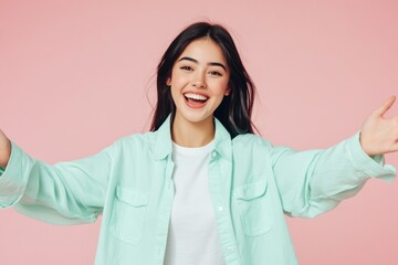Fototapeta premium A woman wearing a green shirt holds her arms open, ready to receive something