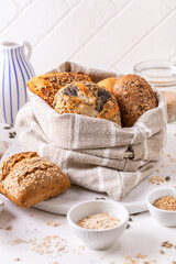 Variation of bread rolls or buns in breadbag  with butter and assorted seeds