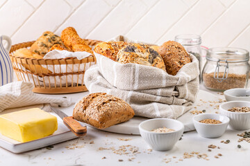 Variation of bread rolls or buns in breadbag  with butter and assorted seeds