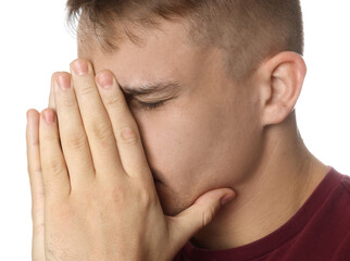 Distressed young man crying on white background