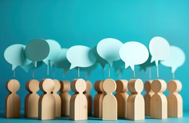 Wooden figures representing people stand in group. Empty light teal speech bubbles float above figure. Communicating, exchanging ideas, opinions, central theme. Social interaction, feedback, public
