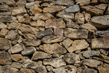 Stones texture of a medieval castle wall. Dry stone pattern of an ancient building made of rocks