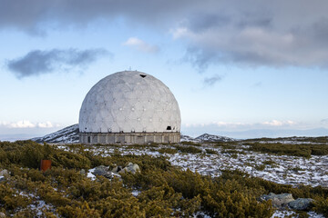 Obraz premium Abandoned dome of an old Soviet military radar from the Cold War. A huge structure in the form of a white sphere on a mountain in the vicinity of Magadan. Magadan region, Siberia, Russian Far East.