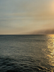 Obraz premium Ocean view looking towards the horizon with a smoke-filled sky