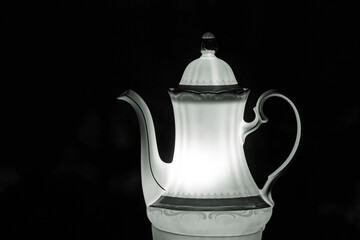 Light object, porcelain coffee pot in the night.