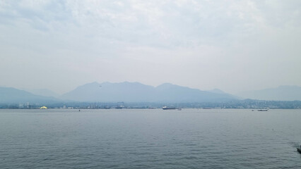 This image shows a view over Victoria Harbor, Vancouver Island, with majestic mountains in the...