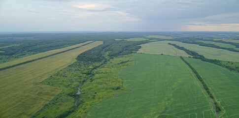 Large field of green grass with a river running through it